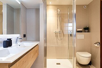 A bathroom with a walk in shower and a toilet