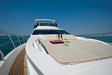 The front of a white yacht with a cushion on the deck