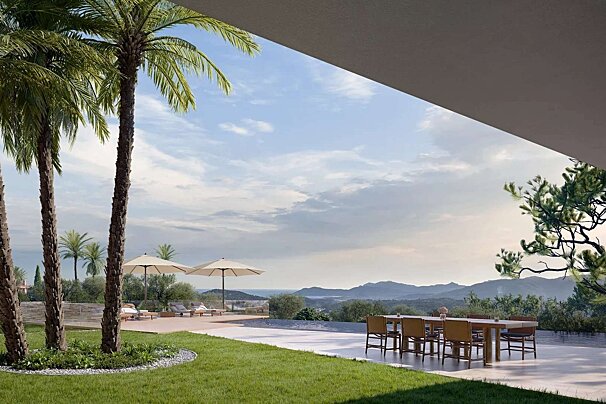 A luxurious outdoor patio with palm trees, dining area, and pool loungers, offering stunning views of distant mountains and a bay under a clear sky.