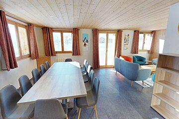 A living room with a long table and chairs