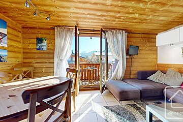 A living room with a couch and a table with alpine property written on the bottom