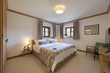 A bedroom with a large bed and a television