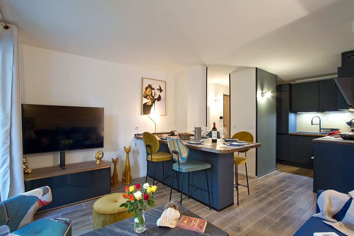 A living room with a table and chairs and a flat screen tv