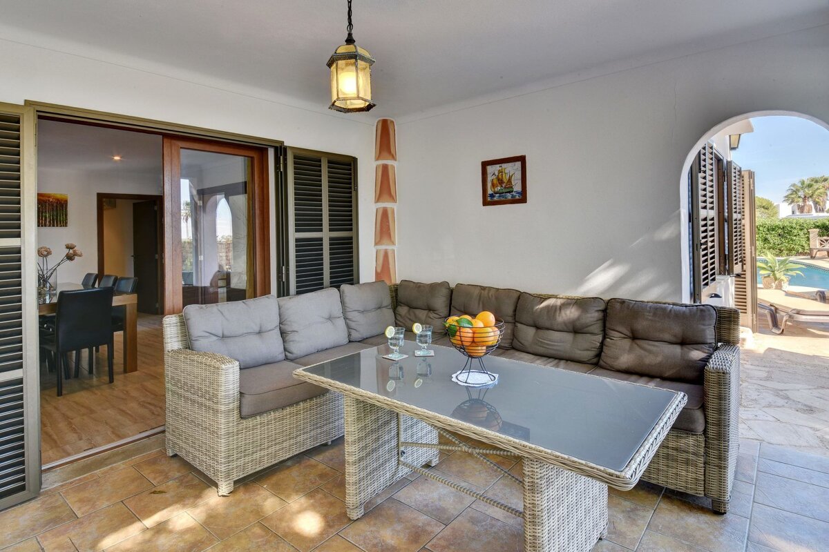 A living room with a couch and a table with a bowl of fruit on it
