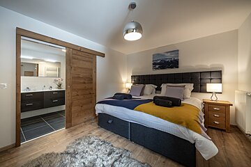 A bedroom with a sliding door leading to a bathroom