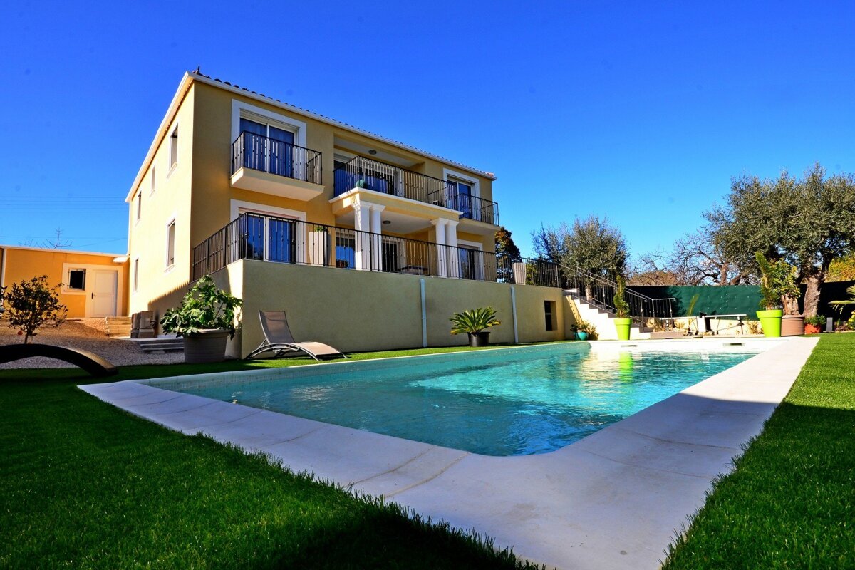 A large house with a swimming pool in front of it