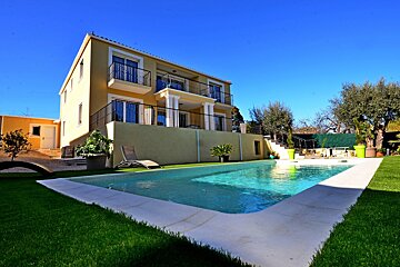A large house with a swimming pool in front of it