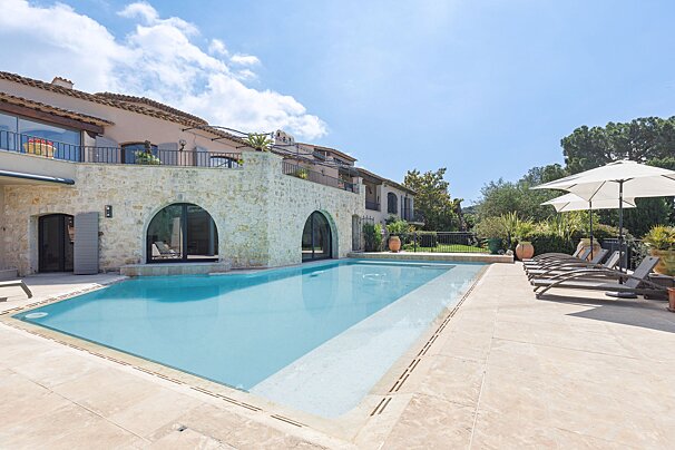 A large house with a swimming pool in front of it