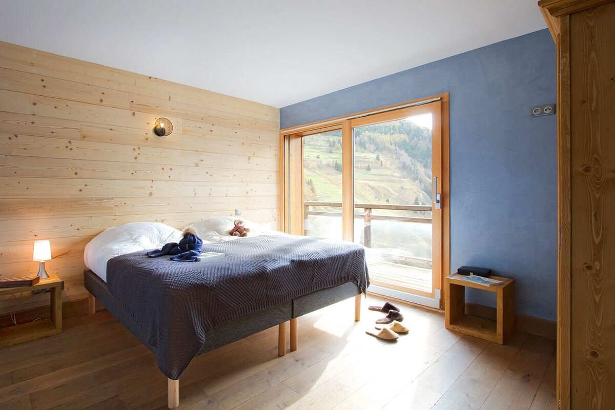 A bedroom with a bed and a sliding glass door