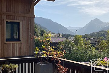 A balcony with a view of the mountains and trees