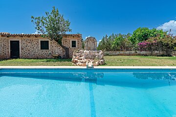A swimming pool with a stone building in the background