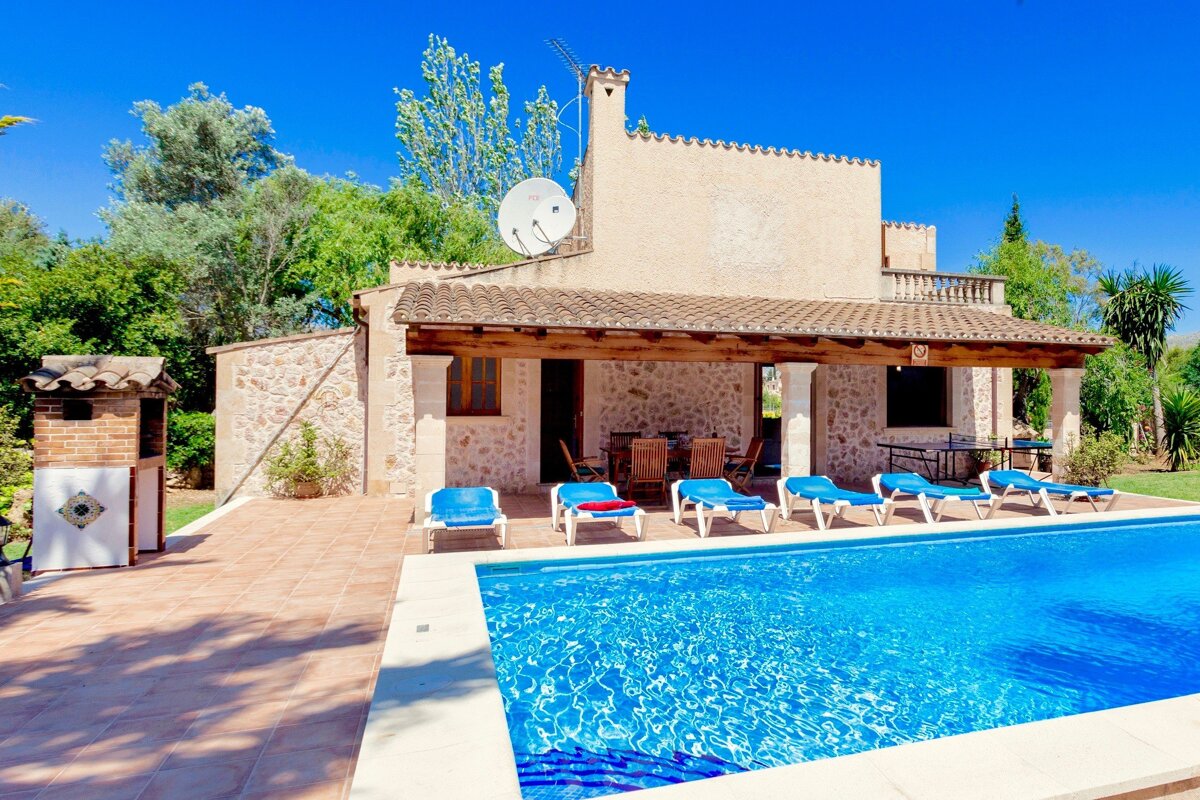 A house with a large swimming pool in front of it
