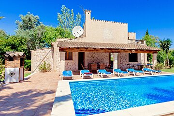 A house with a large swimming pool in front of it