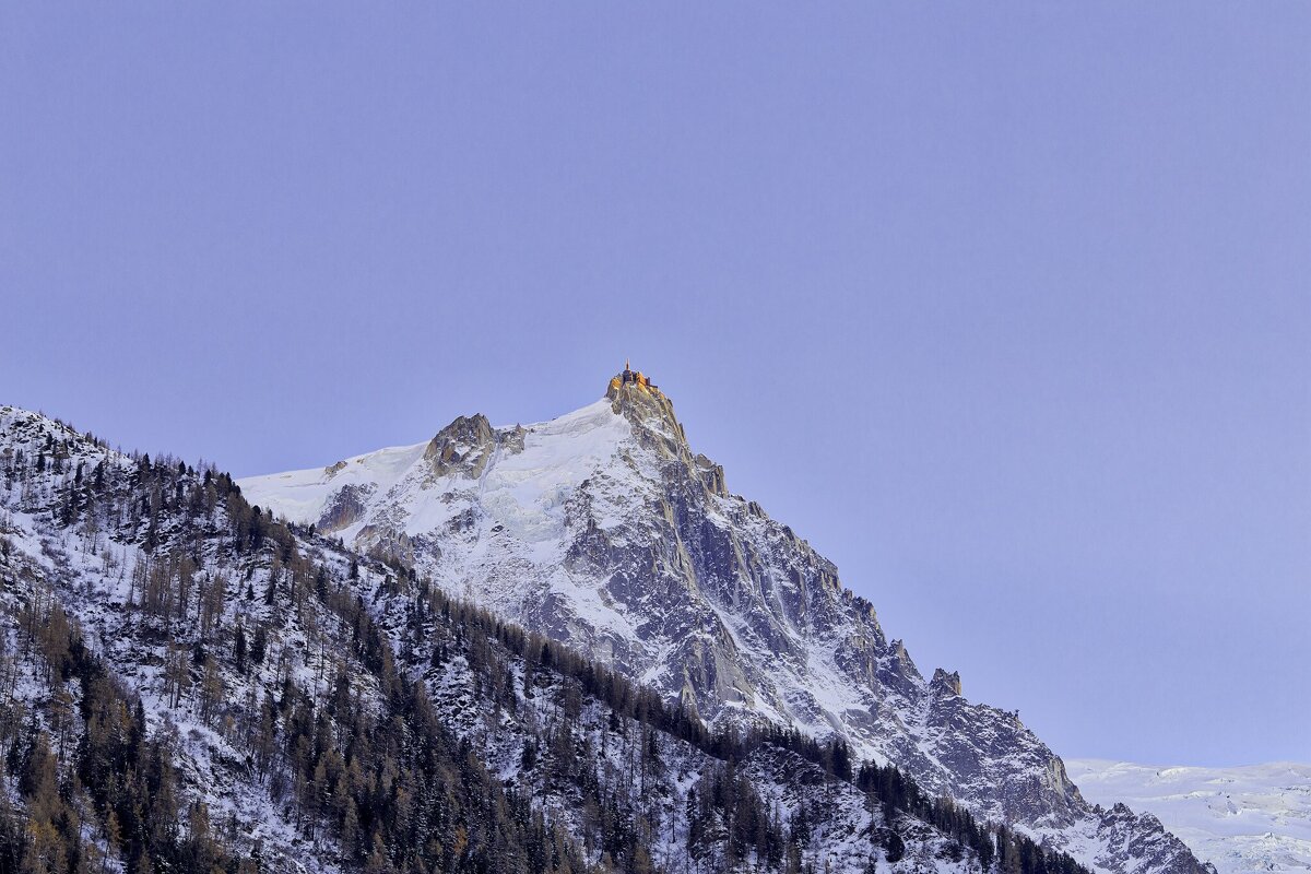 A snowy mountain with a tower on top of it