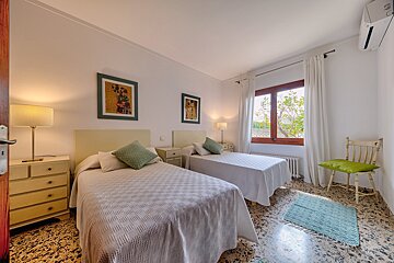 A bedroom with two twin beds and a chair