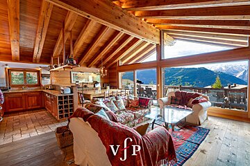 A living room with a view of the mountains and a couch that says vjp