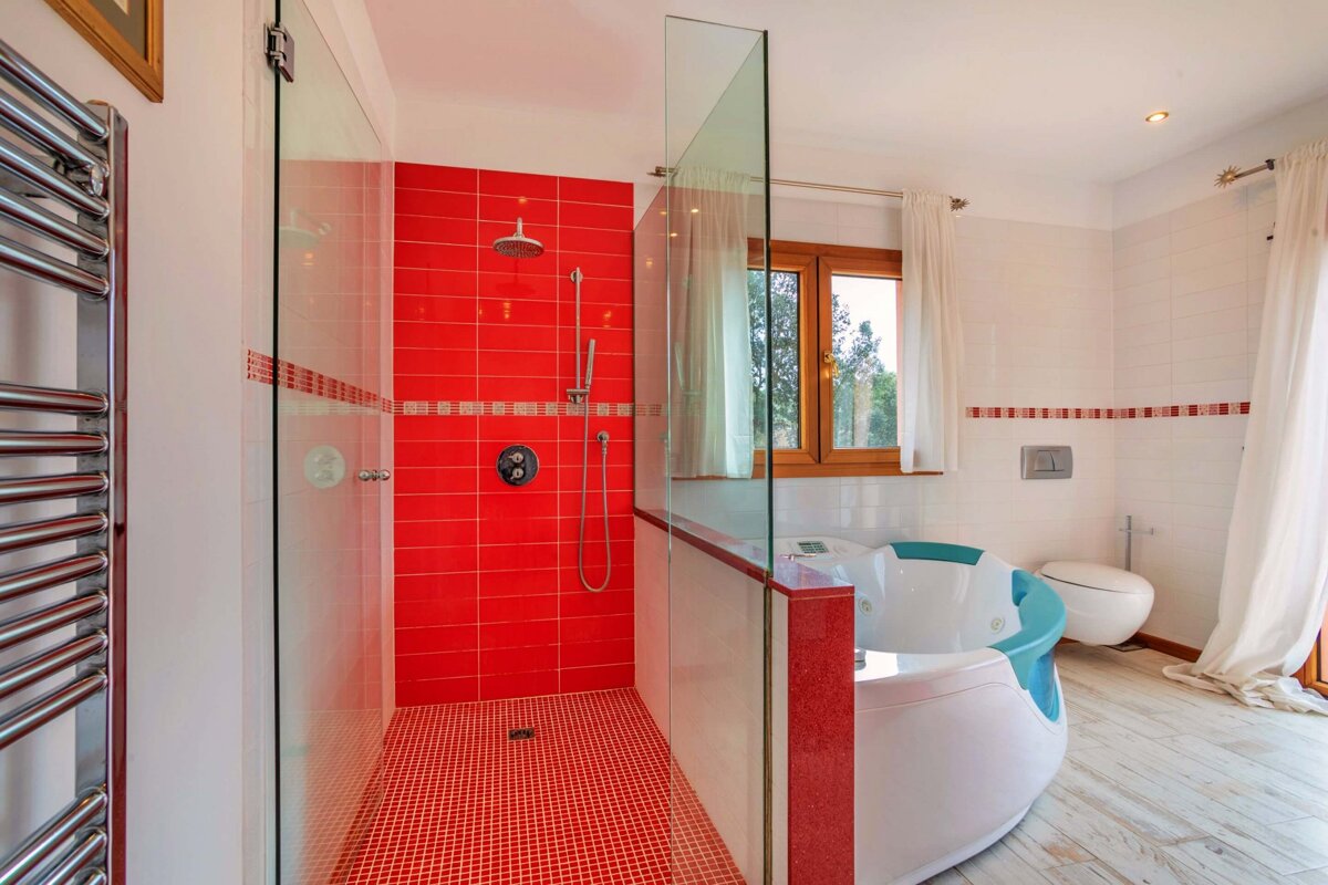 A bathroom with red tiles and a bathtub