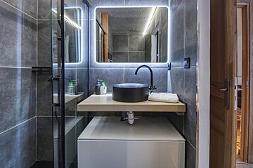 A bathroom with a black sink and a mirror