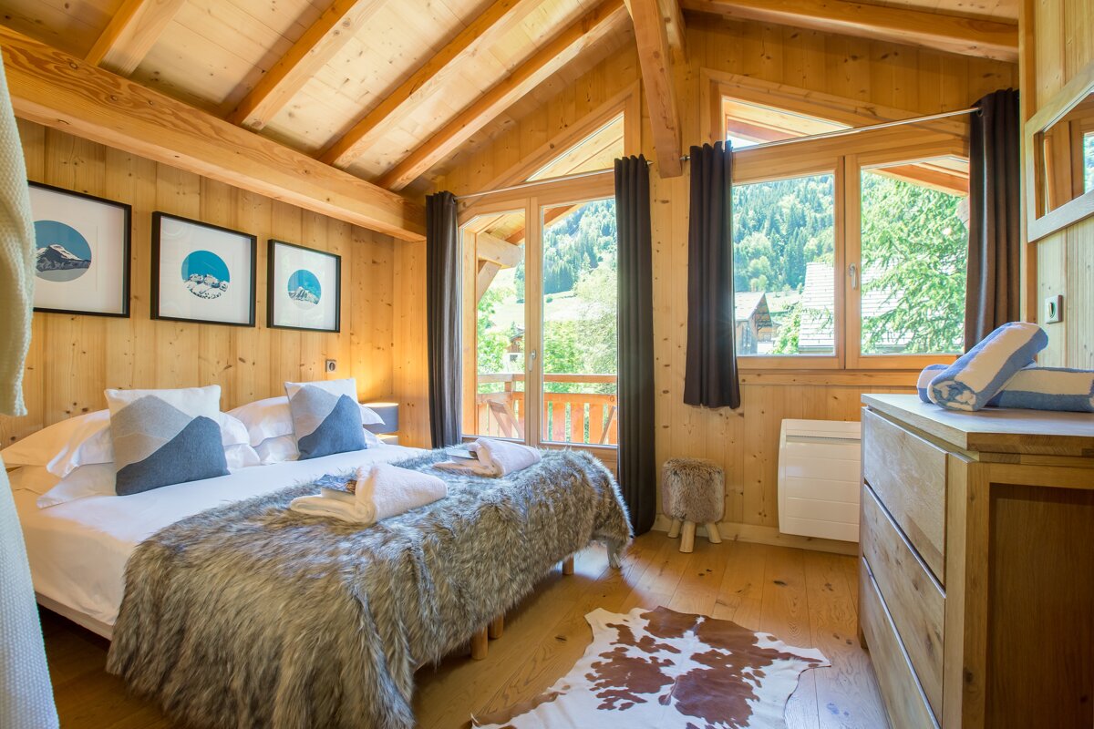 A bedroom with a large bed and a dresser