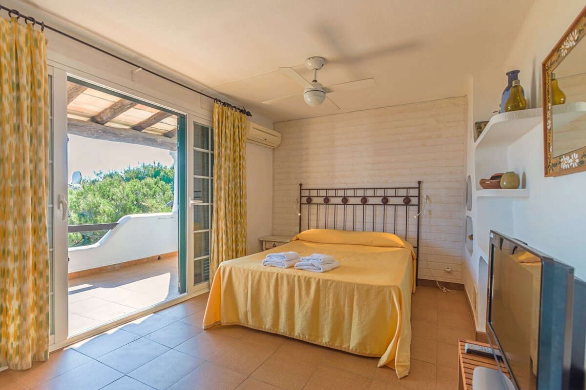 A bedroom with a large bed and a flat screen tv