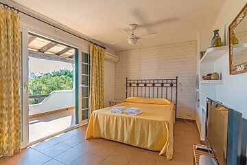 A bedroom with a large bed and a flat screen tv