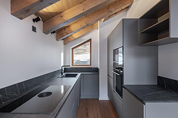 A kitchen with a stove top oven and a window