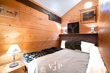 A bedroom with a bed and a lamp with the letter v on it