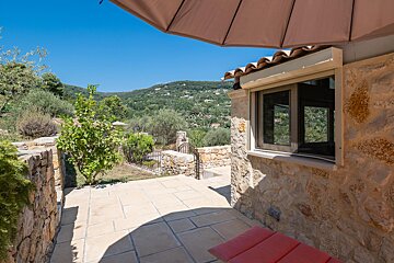 A stone building with a window and a view of the mountains