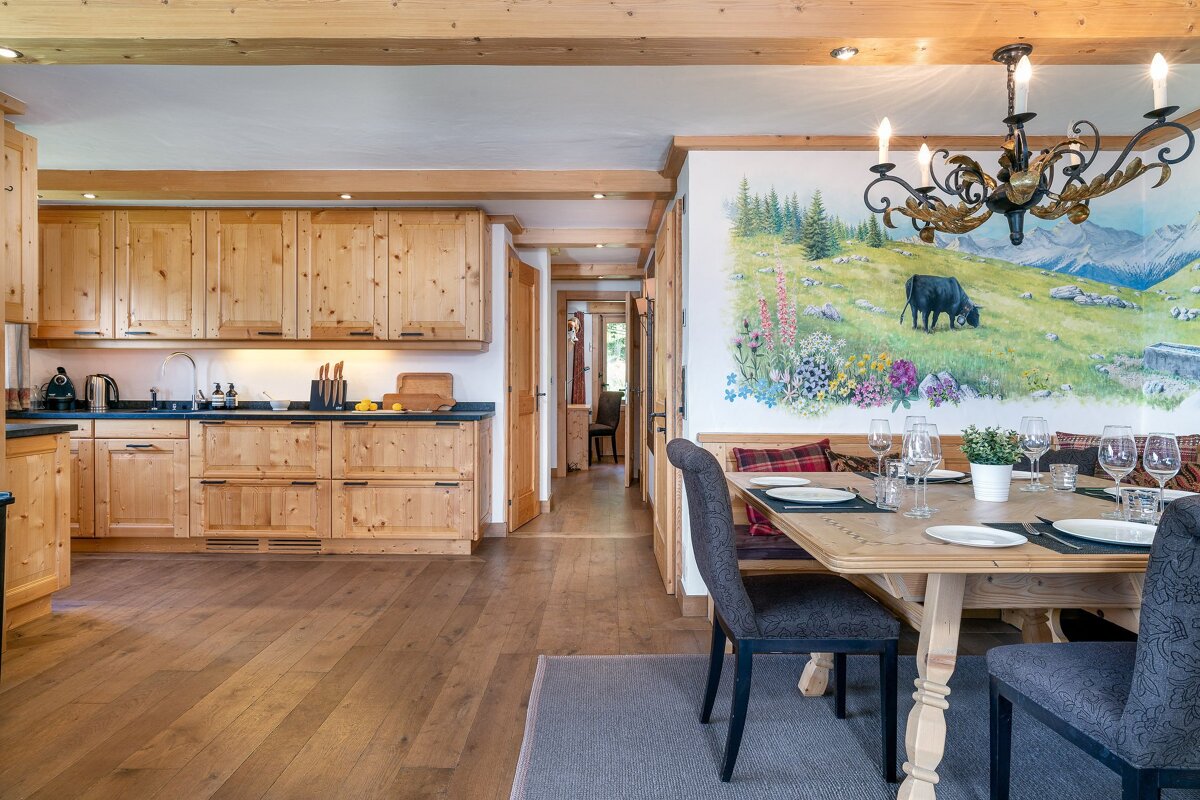 A kitchen and dining room with a painting of a cow on the wall