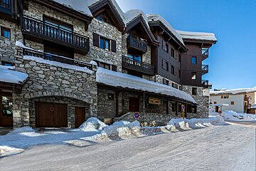 A snowy building with a sign that says ' l' ermitage ' on it