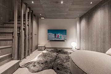A room with a rug and a tv on the wall