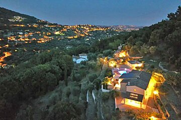 An aerial view of a house surrounded by trees at night