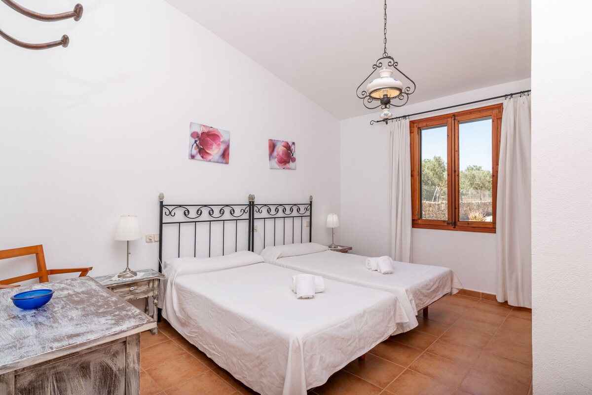 A bedroom with two beds and two pictures on the wall