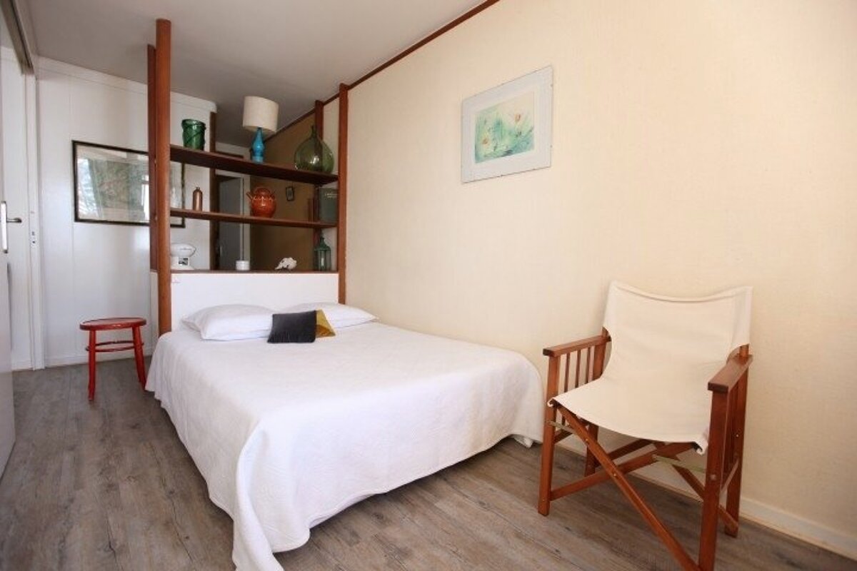 A small bedroom with a bed and a chair