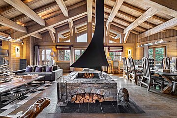 A living room with a fireplace and a wooden ceiling