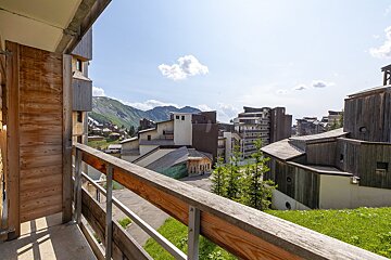 A balcony with a view of a city and mountains