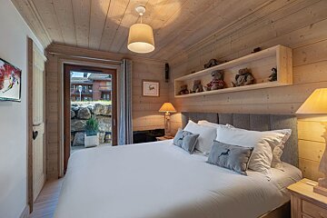 A bedroom with a bed and a nightstand with a heart on it