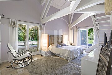 A bedroom with a large bed and a rocking chair