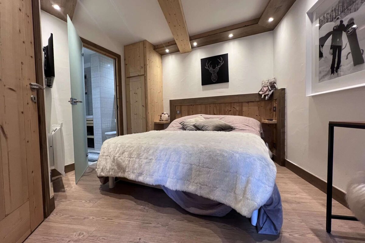 A bedroom with a bed and a picture on the wall