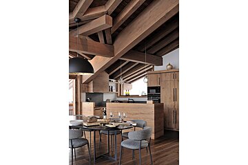 A kitchen and dining area with a wooden ceiling
