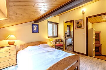 A bedroom with a bed a dresser and a lamp