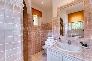A bathroom with pink tiles and the words made in provence by