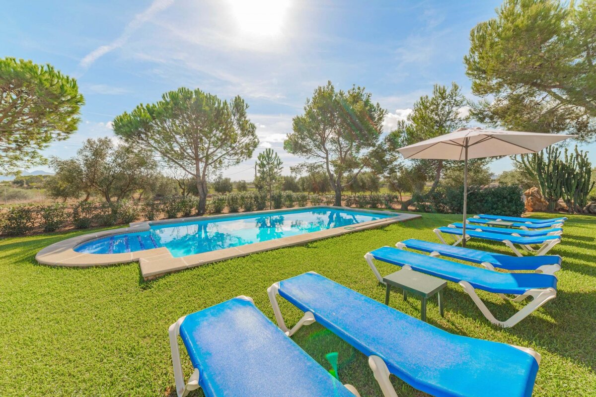 A swimming pool surrounded by blue chairs and an umbrella