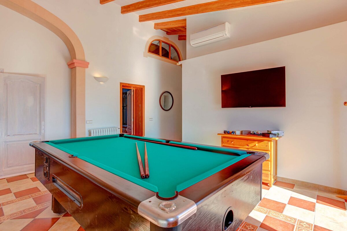 A pool table in a room with a flat screen tv