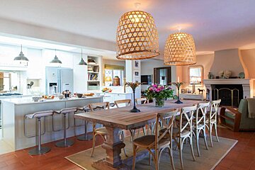 A dining room with a long wooden table and chairs