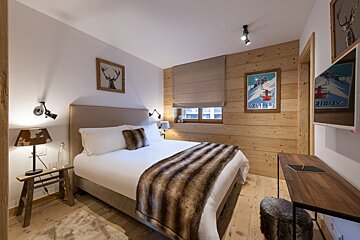 A bedroom with a bed and a picture of a ski lift on the wall