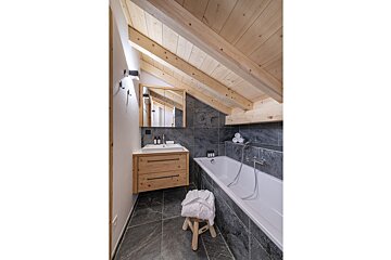 A bathroom with a bathtub a sink and a mirror
