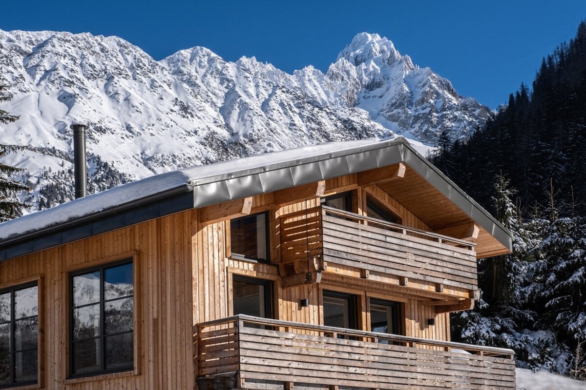 A wooden house with mountains in the background