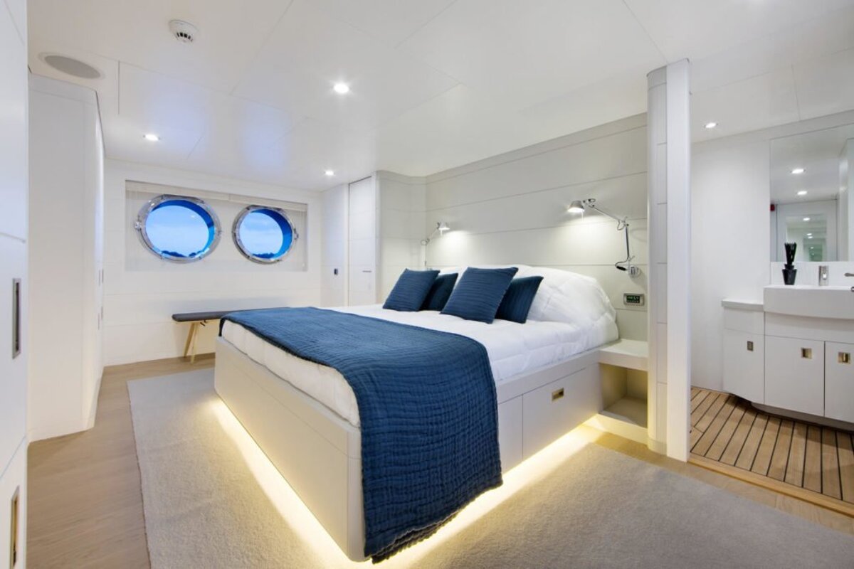 A bedroom with a large bed and two windows