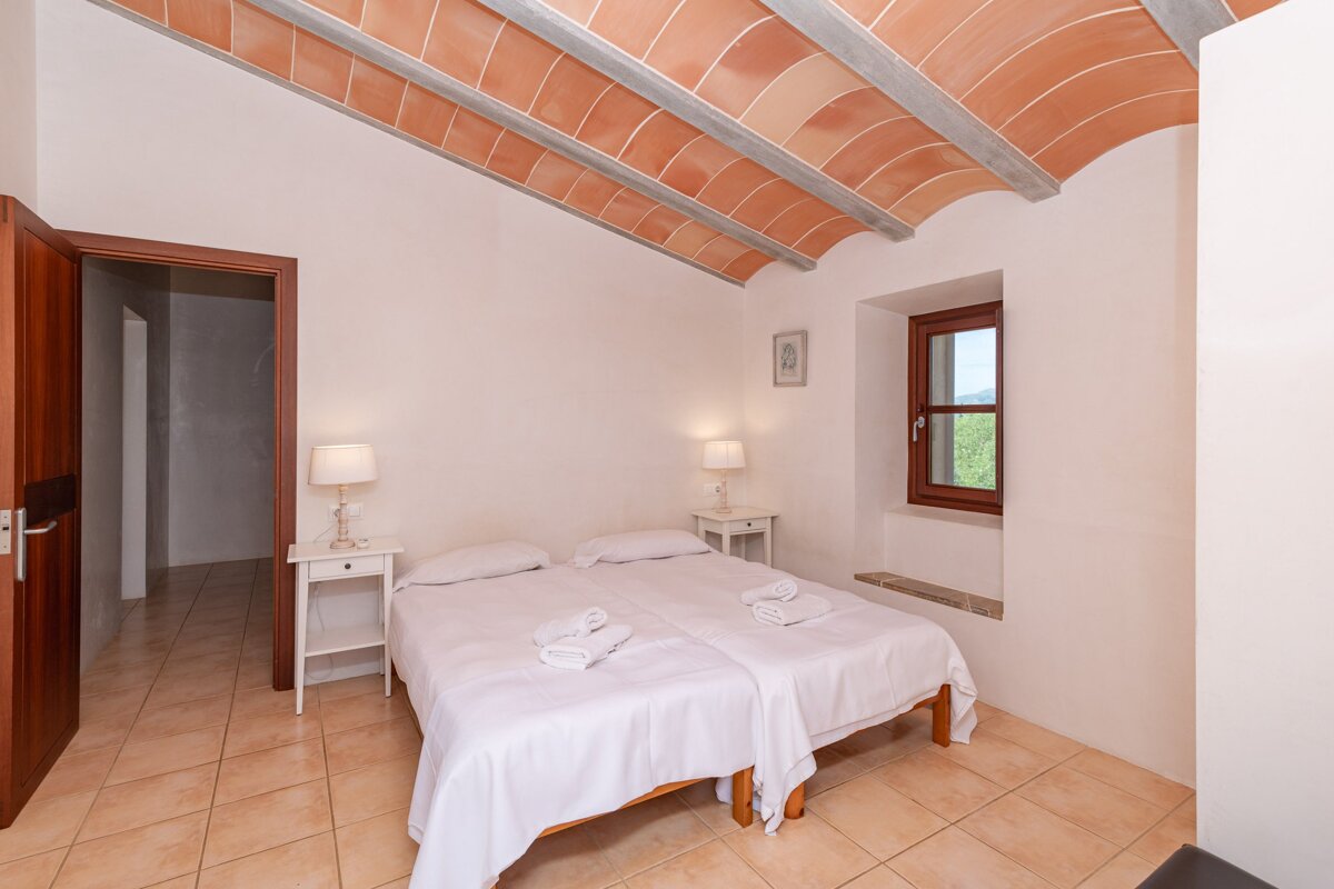 A bedroom with two beds and two lamps